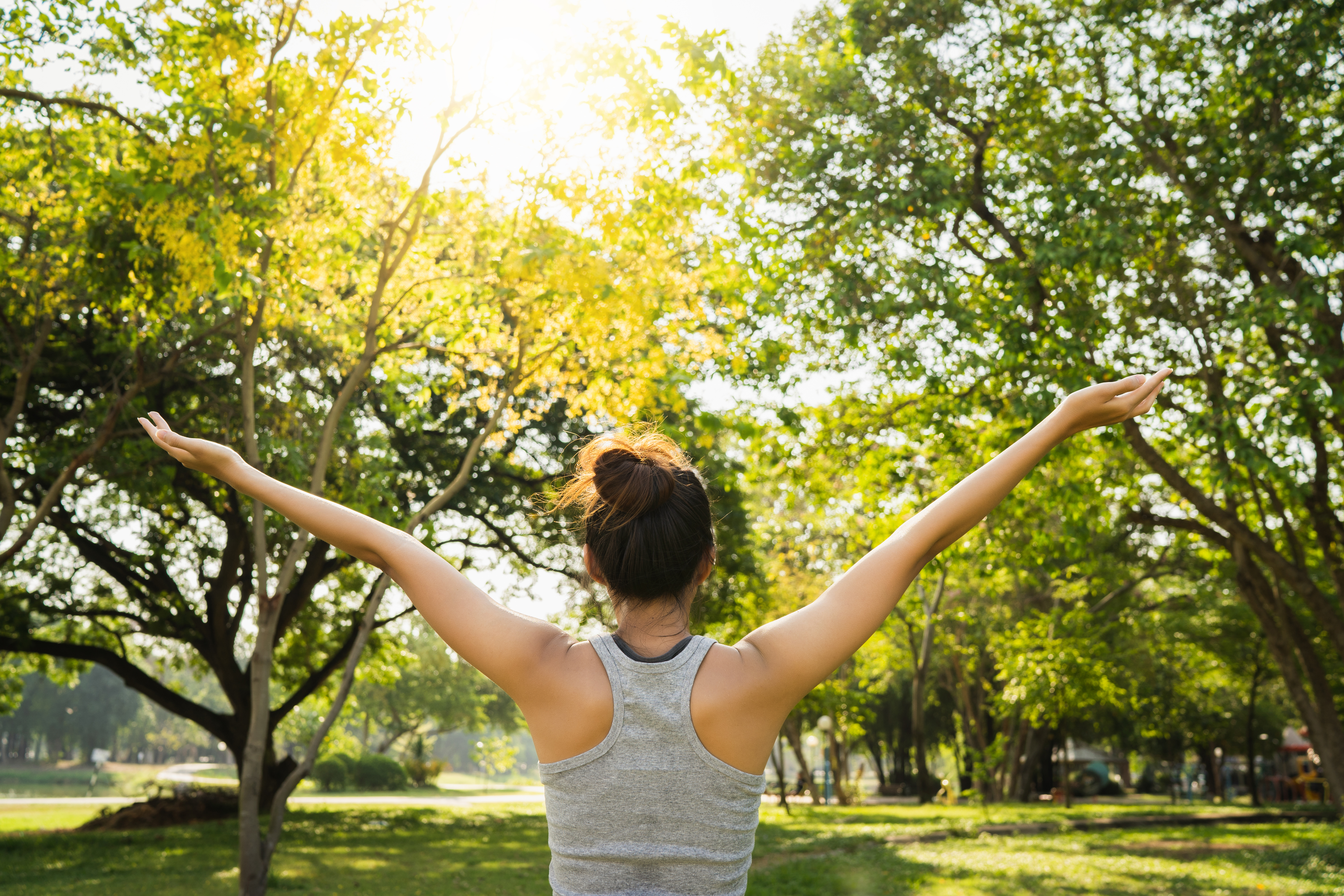 Healthy young Asian runner woman warm up the body stretching before exercise and yoga near lake at park under warm light morning. Lifestyle fitness and active women exercise in urban city concept.